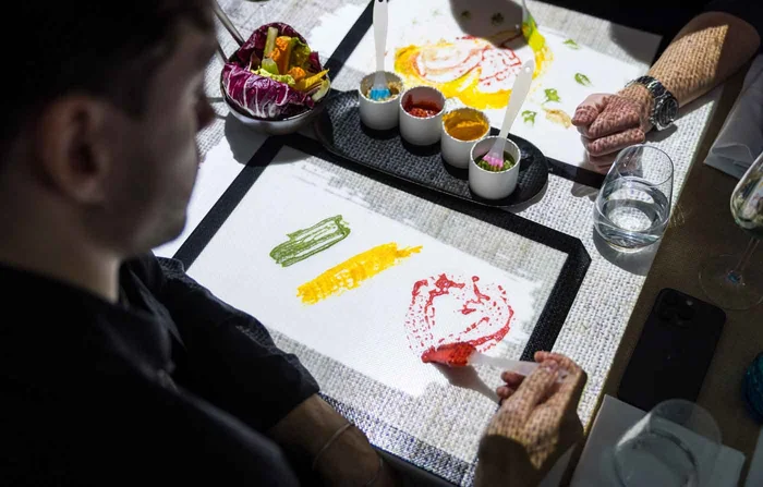 Una visitante pinta con colores comestibles en la mesa